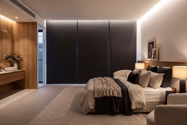 Dark blockout blinds across a bedroom wall