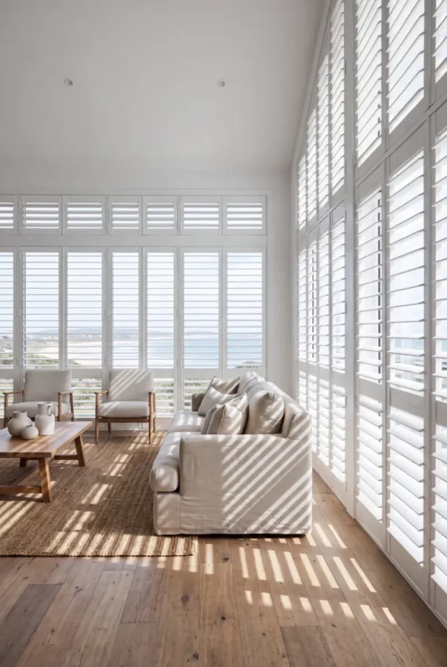 Plantation shutters on tall living room windows